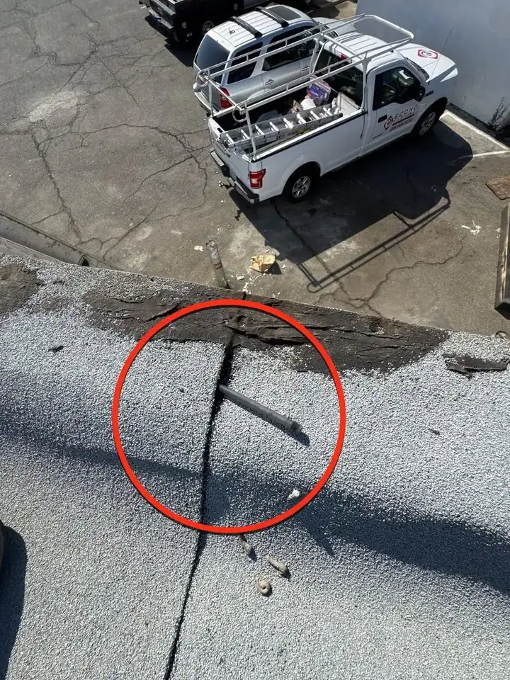 Failing seam and nail pop circled in red during the roof inspection at Beto's Bakery, with an Econo Roofing truck below