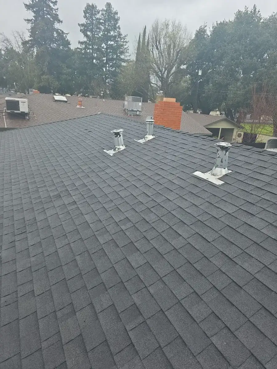Aerial view of a completed dark architectural shingle roof on a Turlock home