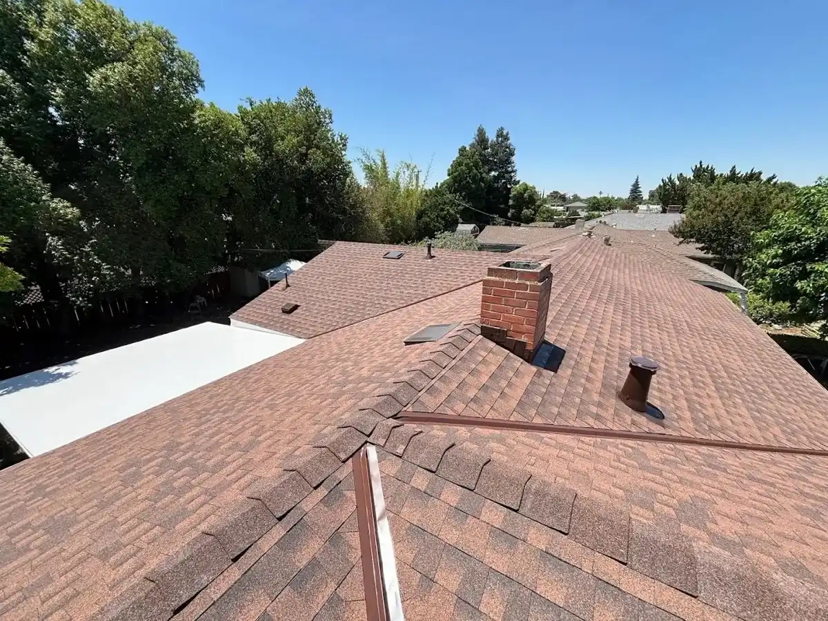 After: new multi-tone asphalt shingle roof with brick chimney by Econo Roofing