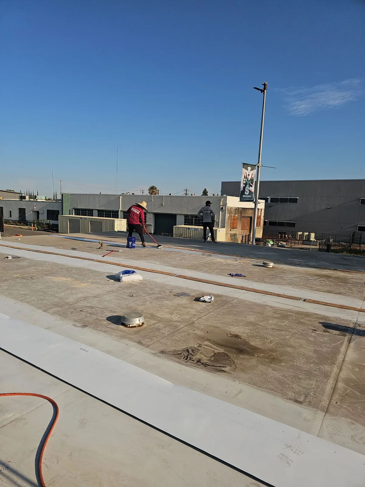 Econo Roofing crew at work on the Manteca High School roof during the TPO coating restoration