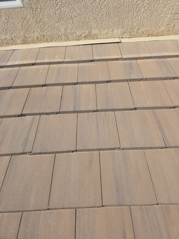 Damaged tiles at stucco wall junction showing failed flashing