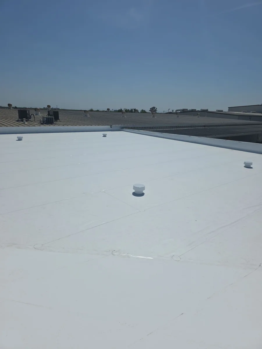 Commercial flat roof with a white membrane and rooftop HVAC units in Merced, CA