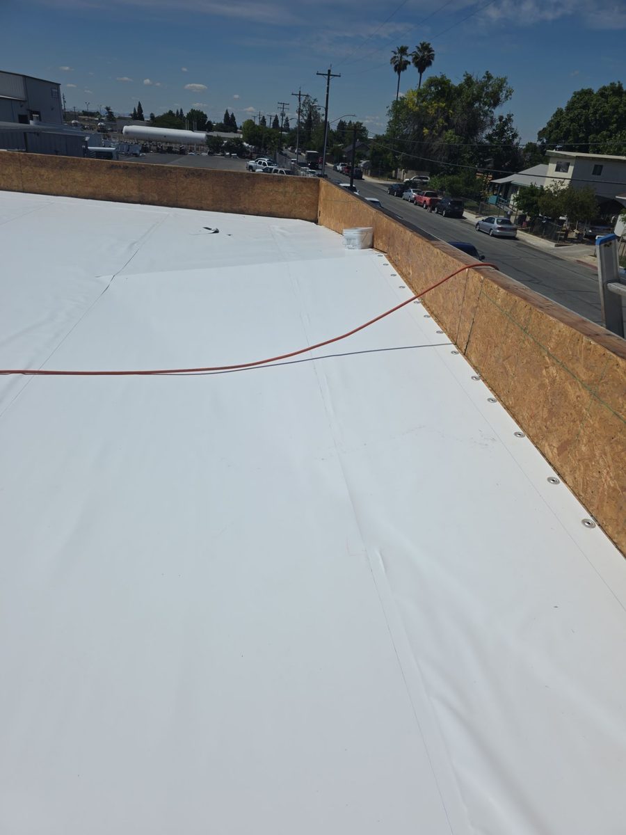 Pristine white elastomeric coating around pipe penetrations at Beto's Bakery after coating