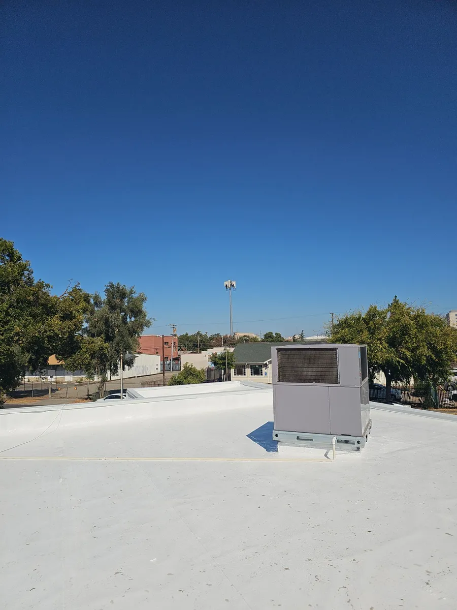 Finished white reflective coating and rooftop HVAC unit on the Beto's Bakery flat roof in Modesto